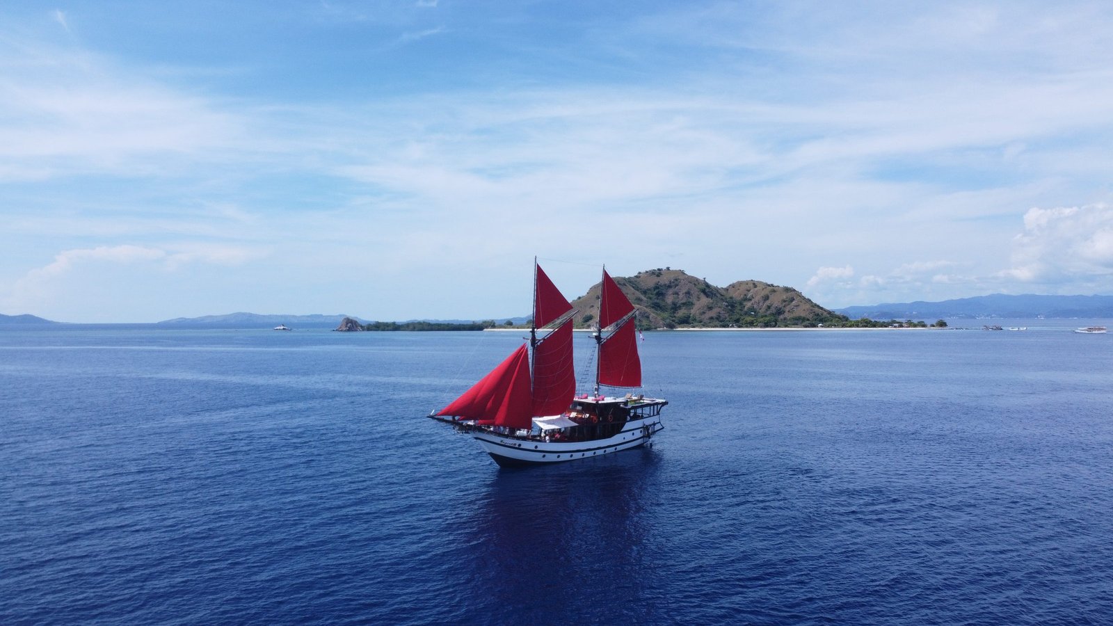 The Supraba phinisi under red sail off Komodo, Indonesia