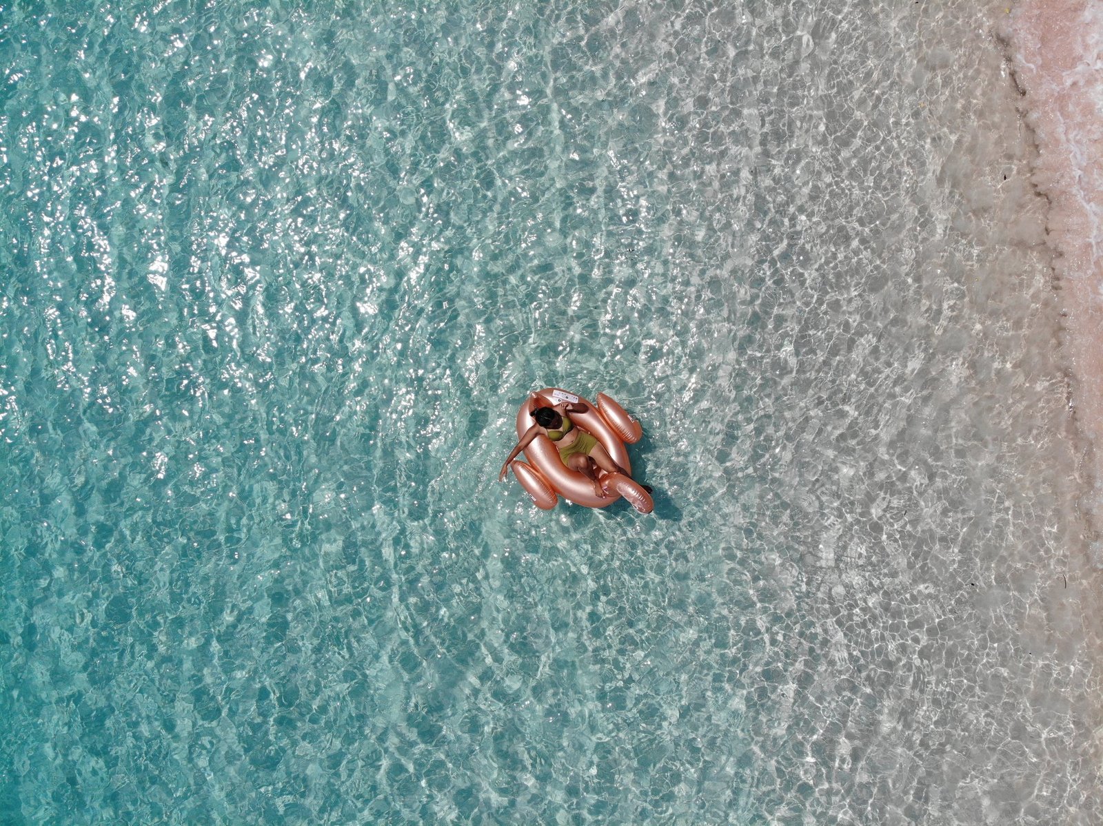 Guest floating in the shallows near Pink Beach